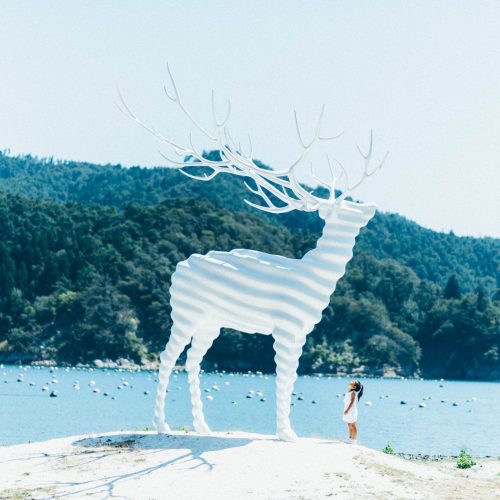 石巻・牡鹿半島のリボーンアート・フェスティバル常設彫刻作品「White Deer (Oshika)」（名和晃平作）と青い海。秋のナイトツアー企画「仲秋の名月と迷い鹿」（石巻グランドホテル 周辺観光・イベント情報）